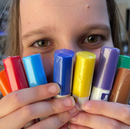 A person holding a set of Pilot Pintor medium pens in various colors including red, blue, orange, yellow, green, and purple.